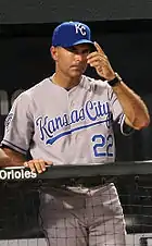 A man wearing a blue baseball cap with the letters "KC" gestures with his hands.