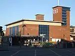 A brown-bricked building with a rectangular, dark blue sign reading "TURNPIKE LANE STATION" in white letters all under a blue sky