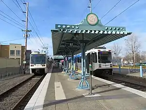 Photograph of a train station with a platform running down the middle and a train on either side