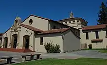 A church with white walls and a brown roof.