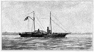 Black and white image of USS Hetzel from a watercolor painting. She lies at anchor, her clipper bow to the right. She carries two masts; a large American flag flies from the gaff of the after (main) mast. The starboard sidewheel is a little aft of directly midship. The single stack is about equally far forward. Superstructure includes a pilot house forward of the stack, some parts of the engines, and a row of cabins aft of the stack. One gun is mounted on the main deck forward, and another is at the stern."