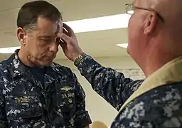 A Naval air officer receives ashes from a military chaplain aboard a U.S. Navy ship, 2011