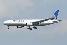 Aircraft landing approach. Side view of a twin-engine jet in flight with flaps and landing gear extended.