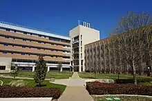 A large, modern building behind a landscaped quadrangle