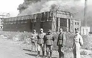 German soldiers in front of a burning Ursus factory