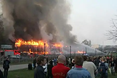 The crowd watches as the fire is extinguished.