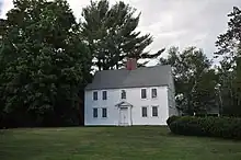 Large white center-chimney colonial house