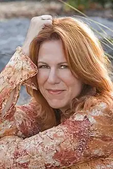 A red-headed woman is smiling