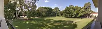 A panorama showing an open grassed area seen from the first floor