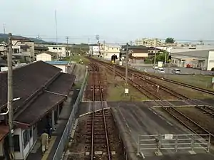 A view from the island platform. There is a level crossing connecting the station building (left) to the island platform and, beyond, to the side platform.