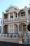 This double-storey Victorian house is at the end of a row of attached town houses. It has an asbestos cement slate roof with a tall chimney and double-storey triangular bay window. The gable extends out over the barge decoration the cast-iron vent.
The do Type of site: House. This beautiful Victorian row house, which dates from the late nineteenth century, is an excellent and well-preserved example of its kind. The front facade is particularly good, with excellent detailing. The decorative barge ornamentation and orpate cast i