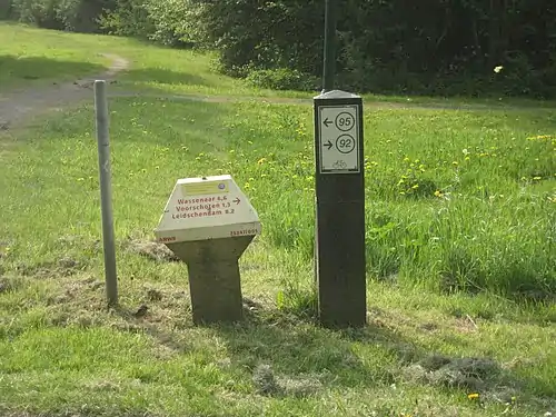 An internode sign alongside a padstool sign that gives local names and distances. The two are used together in the Netherlands.