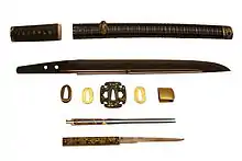 Wakisashi by Sanpin Masatoshi, early 1600s. The disassembled koshirae shows the tsuba (guard), the twin kōgai (hair pin) and the Kozuka (small knife). On display at the British Museum.