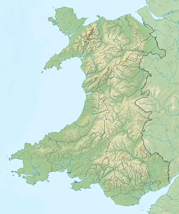 Three maps. The first shows a relief map of Wales with the location of Newport shown in the South East by a red dot. The second shows Newport compared to the United Kingdom, the red dot is in the west. The third shows the UK and Newport relative to the European continent.