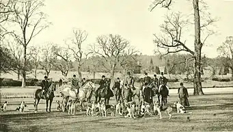 Hunting scene with mounted huntsmen with a pack of dogs