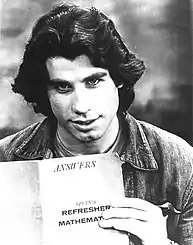 John Travolta holding up a journal