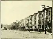 A city block lined with brownstones that are three stories tall