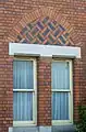 A brickwork pattern above the ground floor windows created using alternating red and blue bricks.