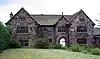 A two-storey stone house with protruding lateral wings