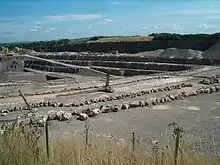 Large expanse of exposed grey rock. Fence in the foreground.