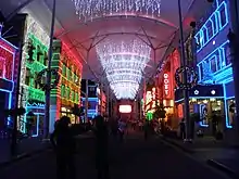 Main Street's buildings and roof illuminated by Christmas lights.