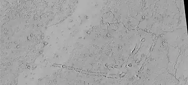 Rootless Cones, as seen by HiRISE under HiWish program.  These group of rings or cones are believed to be caused by lava flowing over water ice or ground containing water ice.  The ice quickly changes to steam which blows out a ring or cone.  Here the kink in the chain may have been caused by the lava changing direction.  Some of the forms do not have the shape of rings or cones because maybe the lava moved too quickly; thereby not allowing a complete cone shape to form.