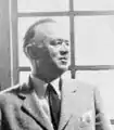 Black and white profile showing head and shoulders of William Wurster, a prominent Bay Area architect. Wurster is dressed in a light-colored suit with a dark tie.