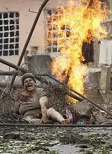 An injured woman sitting in rubble following a Russian bombing attack on Gori