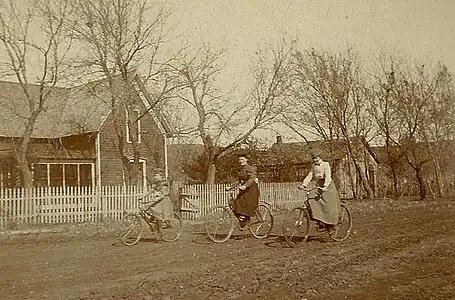 Women on bicycles on unpaved road, US, late 19th century