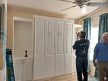 Workers installing a pull-down bed