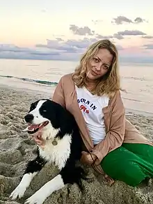 Wurtzel seated in sand next to a dog