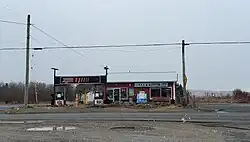 A rural gas station and corner store under snow