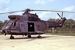 A helicopter parked on a concrete platform.