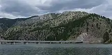 The York-Trout Creek Bridge over the Missouri River below mountains in Helena National Forest.