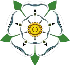 This is the White Rose of York, a white heraldic rose, which is the symbol of the House of York. Traditionally the origins of the emblem are said to go back to Edmund of Langley in the 14th century, the first Duke of York and the founder of the House of York as a Cadet branch of the then ruling House of Plantagenet. The actual symbolism behind the rose has religious connotations as it represents the Virgin Mary, who was often called the Mystical Rose of Heaven.