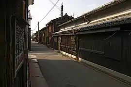 A small street lined by wooden two-storied houses.