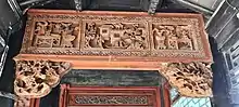 Detail of a carved wooden decorative lintel at the south garden forecourt.