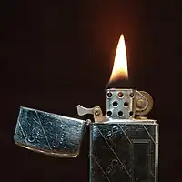 A lit 1968 slim model Zippo