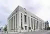 A three-quarter view of an Art Deco marble building seen from across ths street