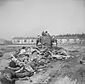 After freeing the camp, British soldiers use bulldozers to push dead bodies into mass graves