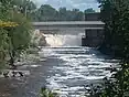 A flowing river with a small waterfall at the end