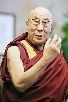 Gyatso dressed in robes raising his hands