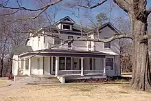 two story white house, with large porch