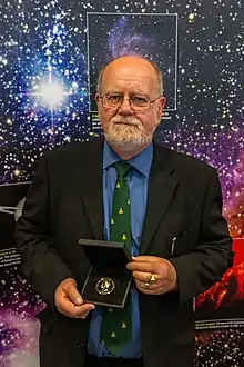 Photograph of John Brown holding a medal