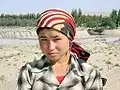 A Uyghur woman from the Xinjiang province of China wears a scarf in the popular 'Italian' fashion, with the ends tied behind her head.