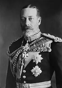 George V is pale-eyed, grey-bearded, of slim build and wearing a uniform and medals