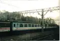 A blue and white Network South East Mk2 and grey and white Intercity Mk1 carriage in Crewe Goods yard during 2001