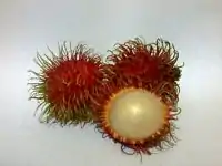 two unpeeled fruits with red spiky skin and one peeled fruit with white inside