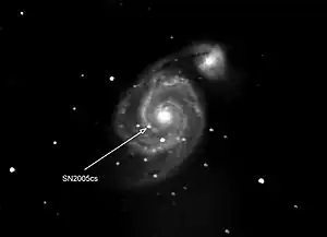 Photograph of supernova in another galaxy. The supernova is pointed by the arrow. The other bright spots are stars of our own galaxy that happen to be in front of the other galaxy