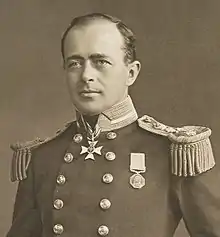 Man with receding hairline, looking left, wearing naval uniform with medals, polished buttons and heavy shoulder decorations